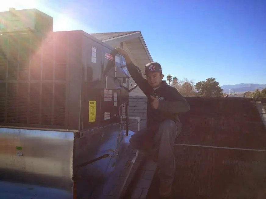 HVAC technician performing Air Duct Cleaning on a rooftop unit in Hampton